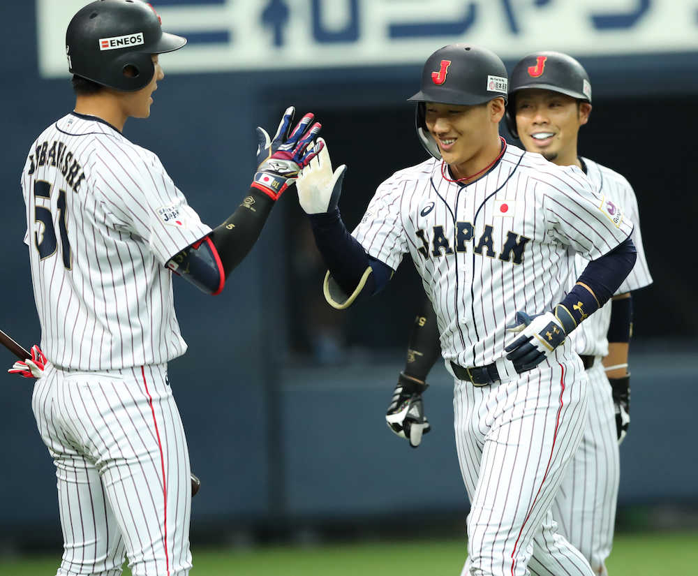 １回無死満塁、吉田正は先制の満塁弾を放ち、近藤（右）、上林（左）に迎えられ笑顔（撮影・井垣　忠夫）