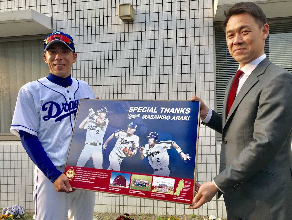 荒木2軍内野守備走塁コーチ（左）は益田副部長から記念パネルを贈られ笑顔
