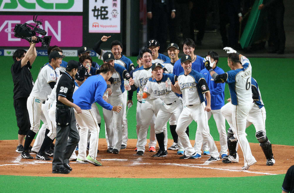 ＜日・オ＞10回、2死満塁、中田がサヨナラ満塁本塁打を放ってホームでナインに出迎えられる（撮影・西海健太郎）