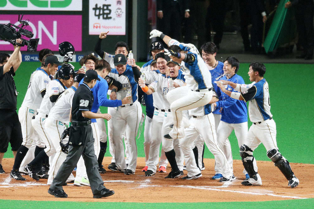 10回2死満塁、中田がサヨナラ満塁本塁打を放ってホームでナインに出迎えられる（撮影・西海健太郎）