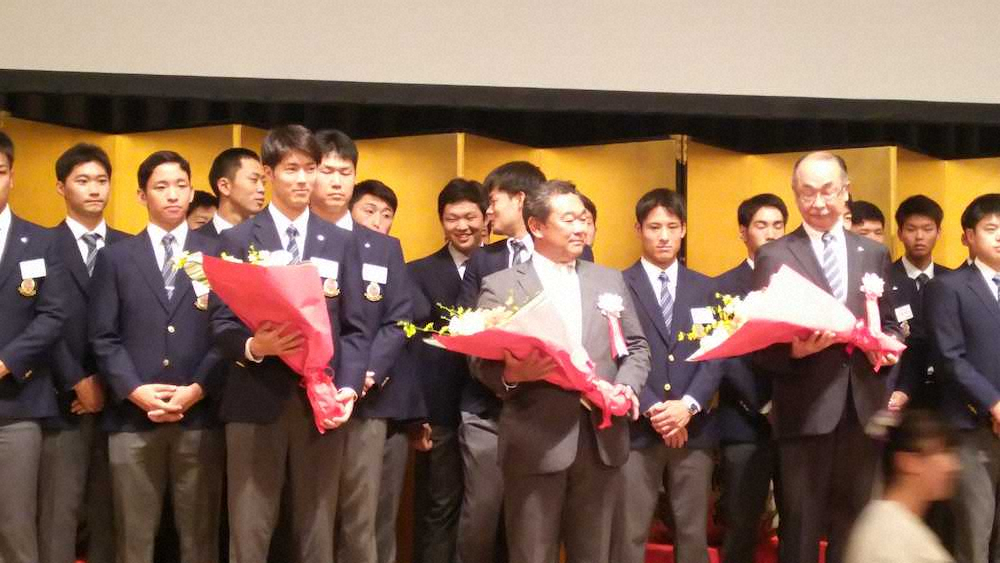 明大野球部祝賀会で花束を贈られた左から森下主将、善波監督、井上野球部長