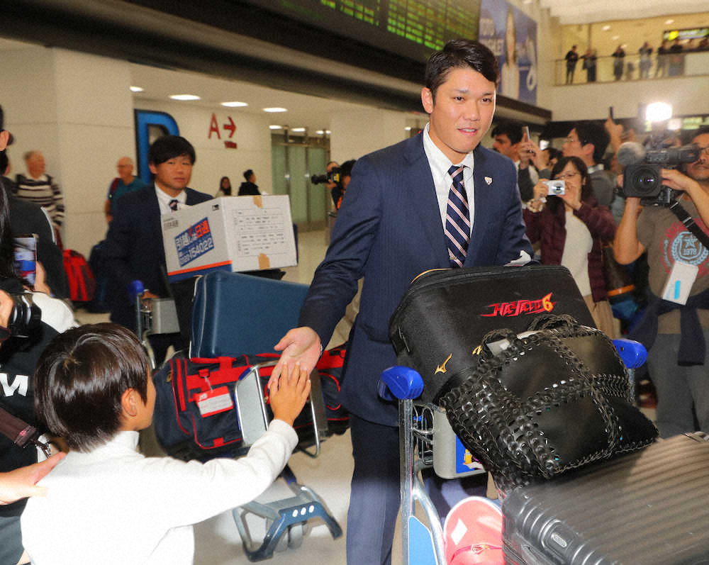【画像・写真】成田空港に到着した坂本勇は出迎えたファンのハイタッチに応える（撮影・島崎忠彦）