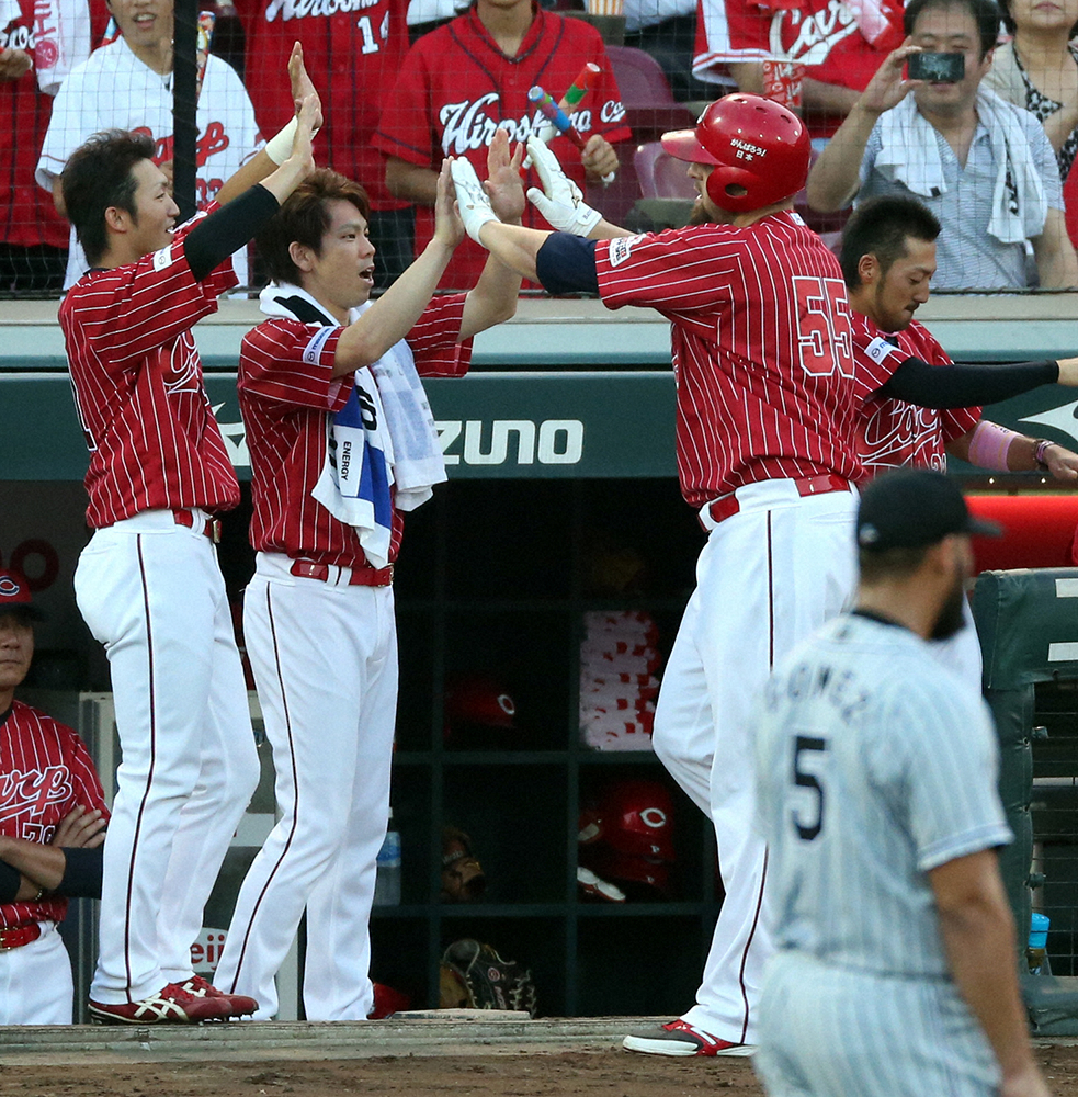 2015年8月、阪神戦の2回、先制ソロ本塁打を放ったエルドレッド（右）を迎える広島の前田（中央）と鈴木