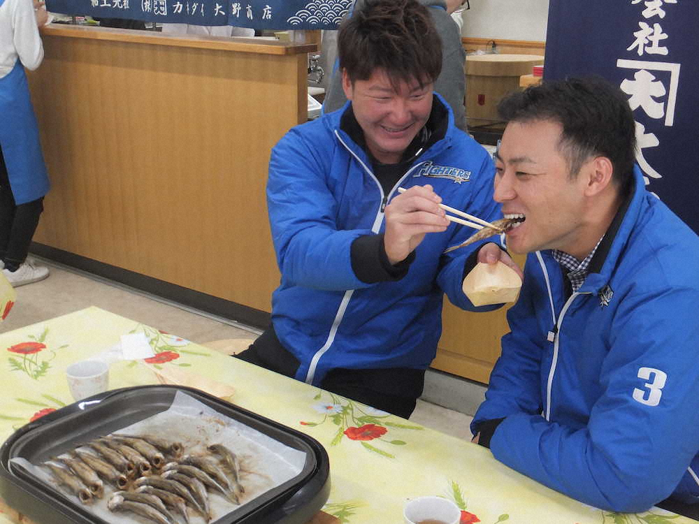 むかわ町の名物であるししゃもを日本ハム・渡辺（左）に食べさせてもらう田中賢介氏