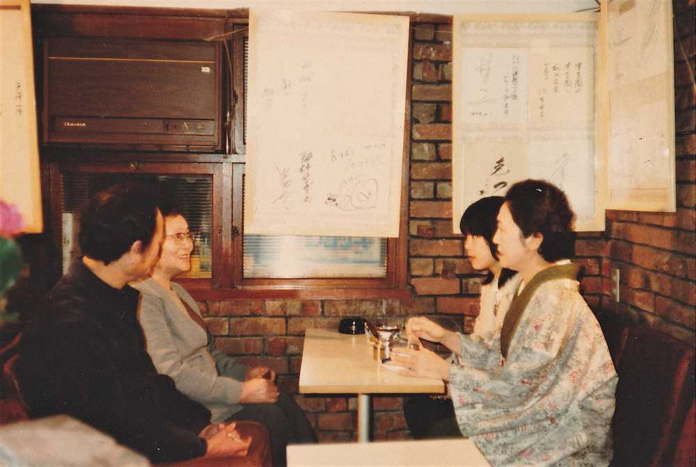 甲子園シミズで作家・佐藤愛子さん（右）と再会した清水浪子さん（左から2人目）と長男・昭さん（左端）。佐藤さんの娘・響子さんもいっしょだった。1975年ごろ＝清水栄子さん提供＝。壁に佐藤さんが書いた色紙がある。