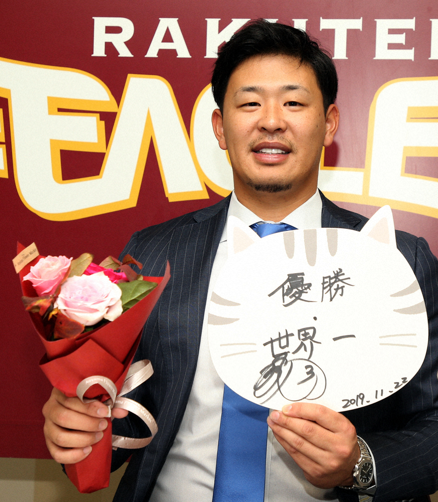 契約更改で来季の抱負を書いた色紙とバラの花を手にする楽天の浅村栄斗内野手
