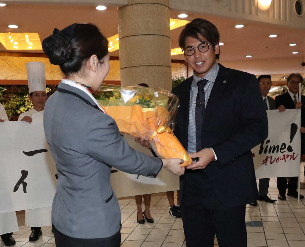 宿泊ホテルのスタッフから花束を受け取る梅野（右）　（撮影・平嶋　理子）　　　　　　　　　　　　　　　　　　　　　　　　　　　　　　　　　　　　