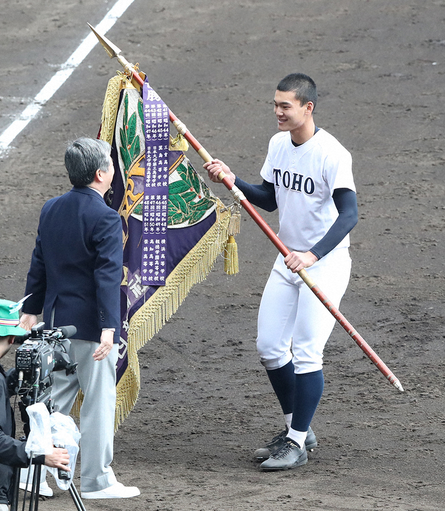 昨年の選抜高校野球で優勝旗を受け取る東邦の石川主将（右）