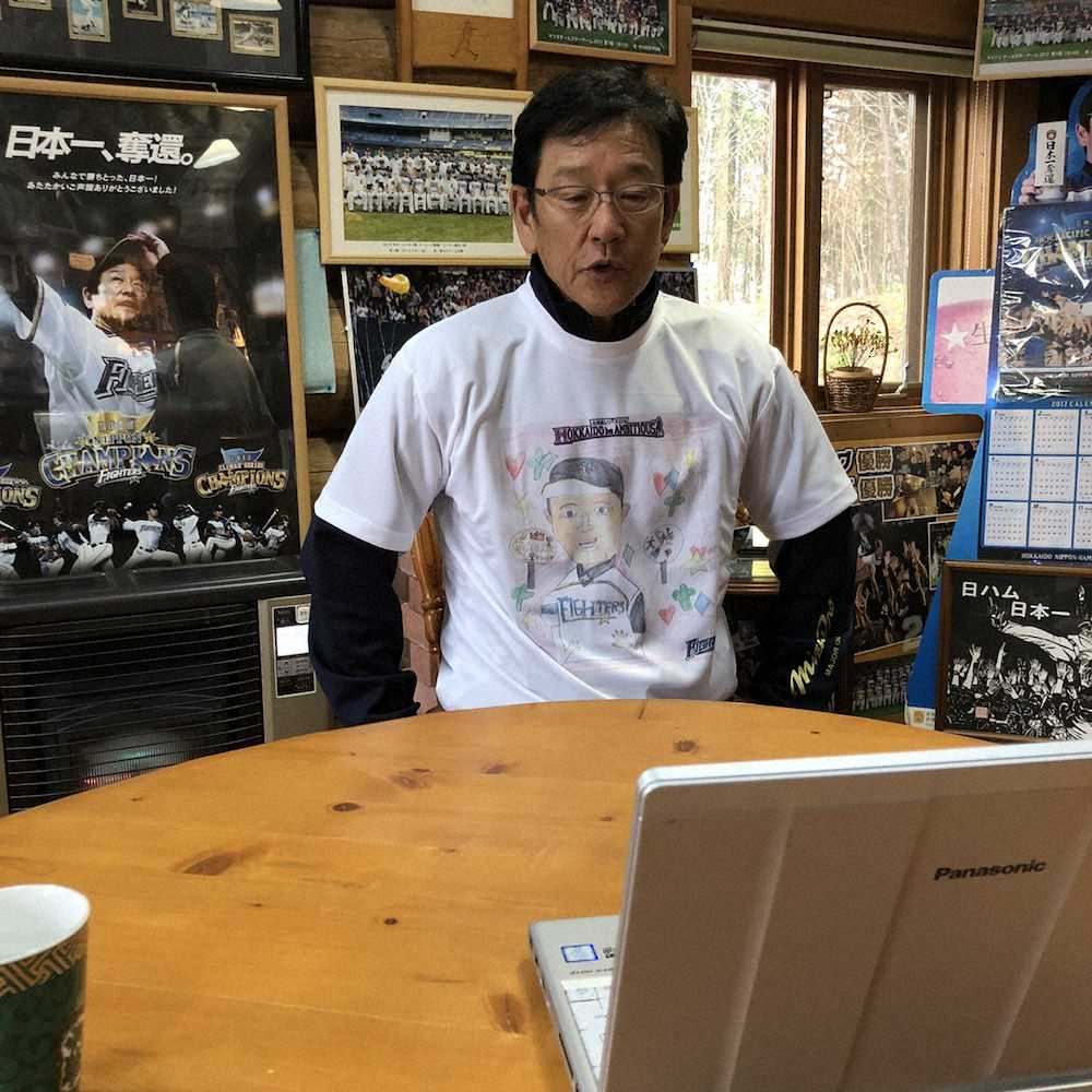 キッズお絵かきコンテストのTシャツを着用し、生活拠点を置く「栗の樹ファーム」でインターネット電話「スカイプ」を通じて取材対応する日本ハム・栗山監督（球団提供）