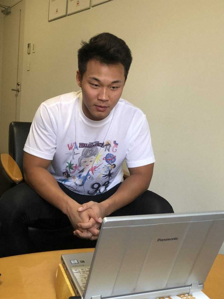 キッズお絵かきコンテストのTシャツを着用し、札幌市内の合宿所でインターネット電話「スカイプ」を通じて取材対応する日本ハム・王柏融