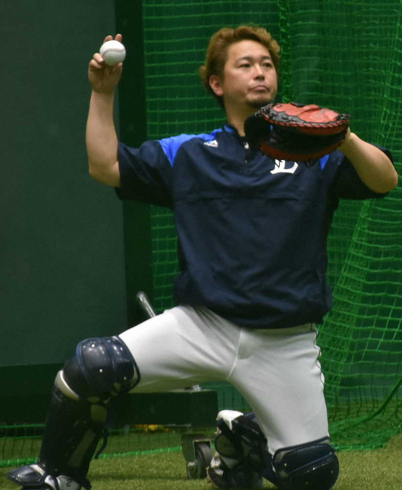 室内練習場で投手陣の球を受ける西武・岡田