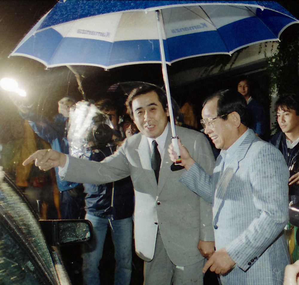 1987年10月16日、吉田前監督の自宅を訪れ会談し、傘を差してもらい帰りの車に乗り込む村山新監督