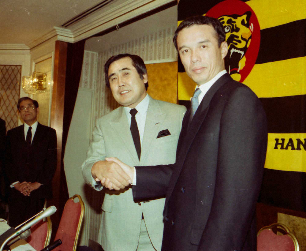 1989年10月18日、辞任の村山監督（左）は次期監督就任の中村新監督と並んで会見し笑顔で握手を交わす