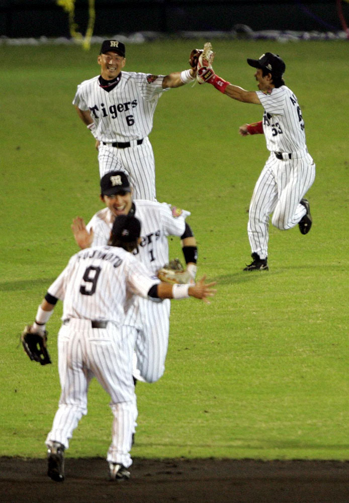 2005年9月29日、優勝の瞬間、ハイタッチを交わしながらマウンドへ向かって歓喜のダッシュする赤星憲広外野手（奥、右）とウイニングボールをキャッチした金本知憲外野手（奥、左）