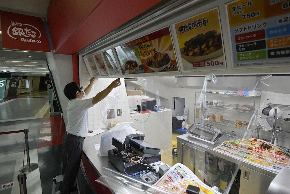 京セラドームで新型コロナウイルス感染予防のため、飛沫防止用の透明シートを設置する売店の関係者