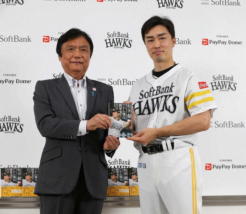 福岡県内の中学・高校に寄贈した本を手にする小川県知事（左）と和田（撮影・中村達也）