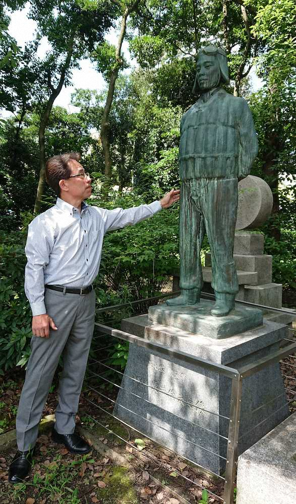 大阪護国神社に建つ「粟井俊夫之碑」に手を差しのべる粟井一夫さん