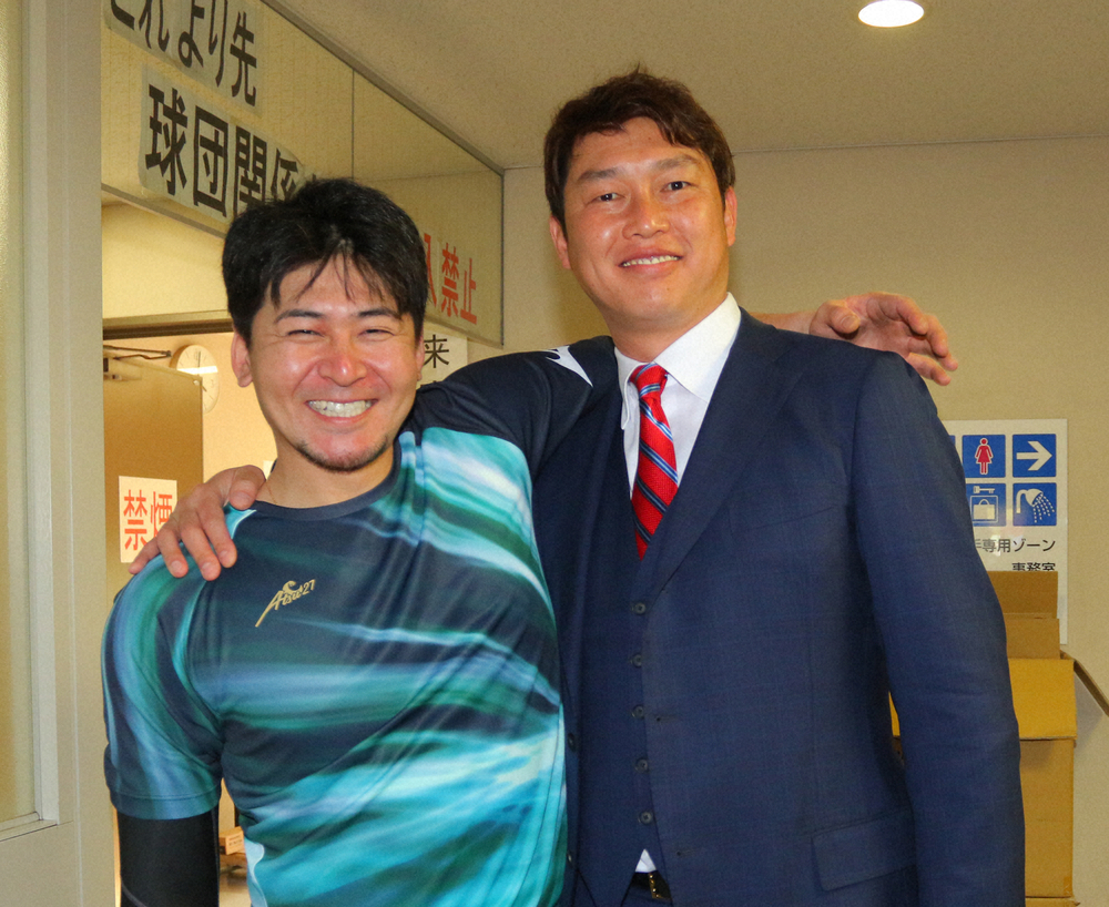 今春キャンプで、広島の会沢翼捕手（左）と笑顔で肩を組むスポニチ評論家の新井貴浩氏
