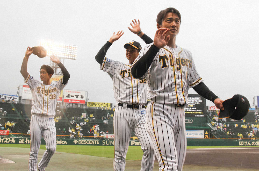 雨で中止が決まり、ファンに挨拶する阪神の（左から）小幡、井上、熊谷　（撮影・平嶋　理子）