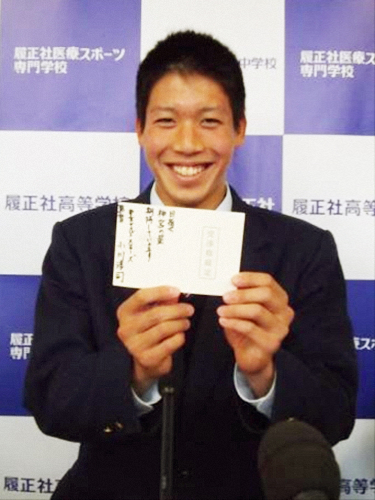 10年、交渉権確定のクジを手に笑顔を見せる山田哲