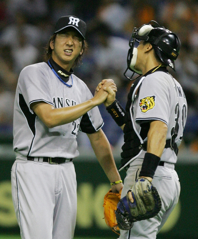 2007年9月9日の巨人戦で、10連投で40セーブ目を挙げた阪神・藤川球児投手（左）は疲れきった表情で阪神・矢野輝弘捕手（右）と握手をする