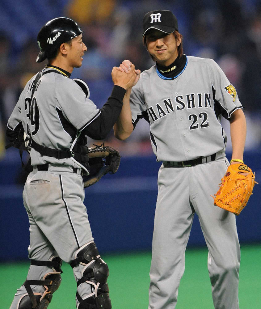 08年4月24日、同点の延長12回から登板して無失点に抑え、矢野（左）と笑顔で握手する藤川