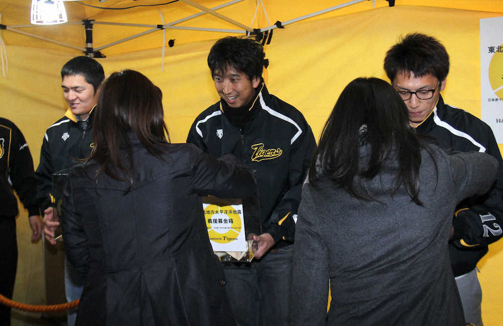 2011年3月18日、募金をしてくれた女性に笑顔で感謝の言葉をかける藤川球児（中）ら阪神選手