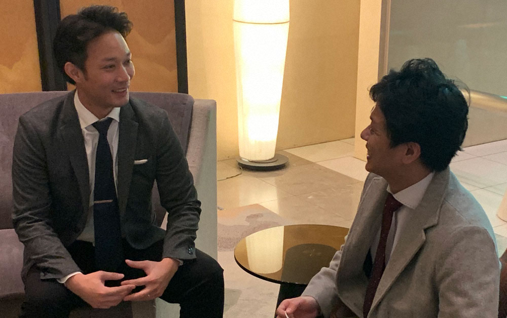 インタビュー後、齋木記者（右）と談笑する一般社団法人日本未来スポーツ振興協会の小川代表