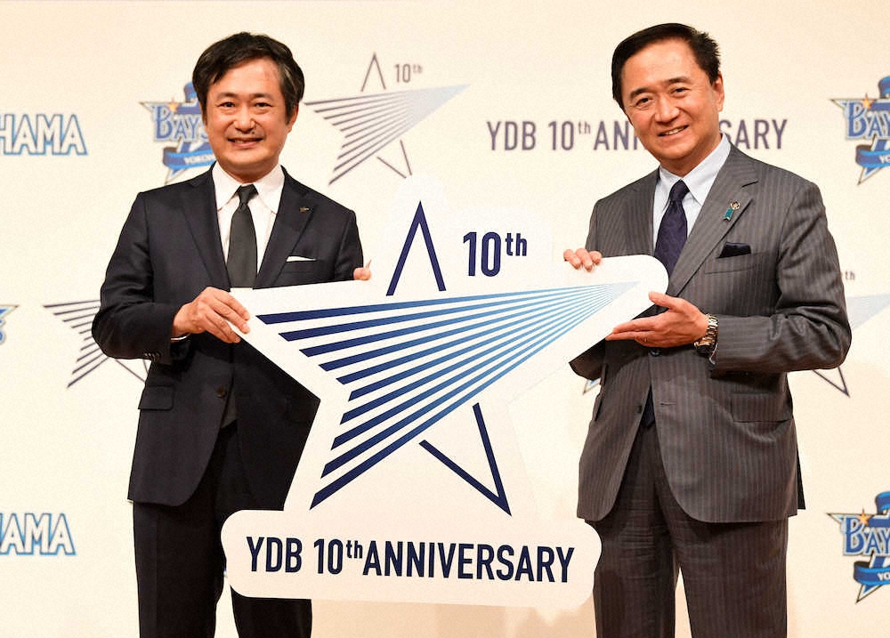 DeNA10周年のロゴを手に笑顔を見せるDeNA・岡村信悟球団社長（左）と神奈川県の黒岩祐治知事