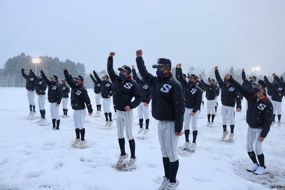 雪が降る中、選抜出場決定の吉報を受けてガッツポーズでジャンプする広島新庄ナイン