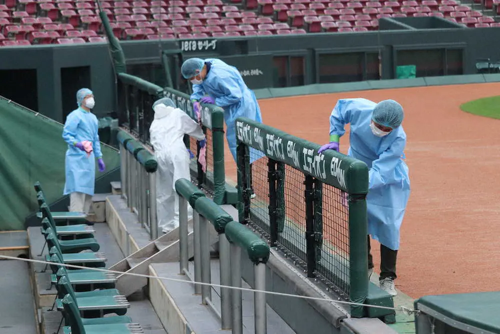 防護服を着て一塁ベンチを消毒するマツダスタジアムの職員