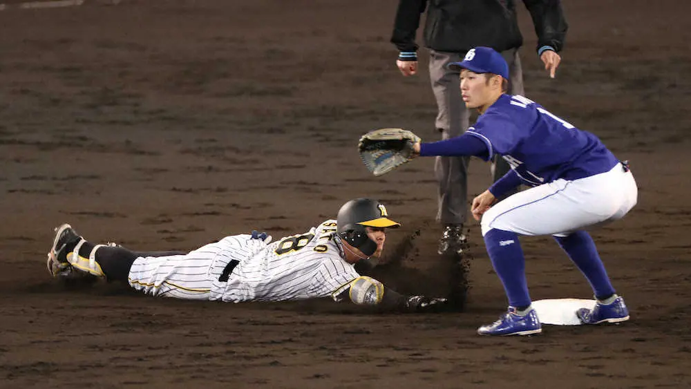 二塁打を放ち、二塁へヘッドスライディングする阪神・佐藤輝明。右は中日・京田陽太（5月11日、甲子園）