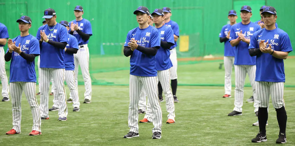 6月18日、青い帽子とTシャツを着用して医療従事者に感謝の拍手を送った矢野監督（中央）ら阪神ナイン