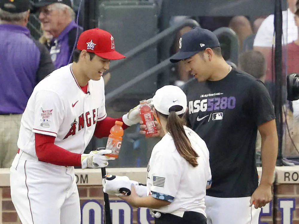 本塁打競争1回戦の合間に、マリナーズ・菊池（右）から飲み物を受け取るエンゼルス・大谷