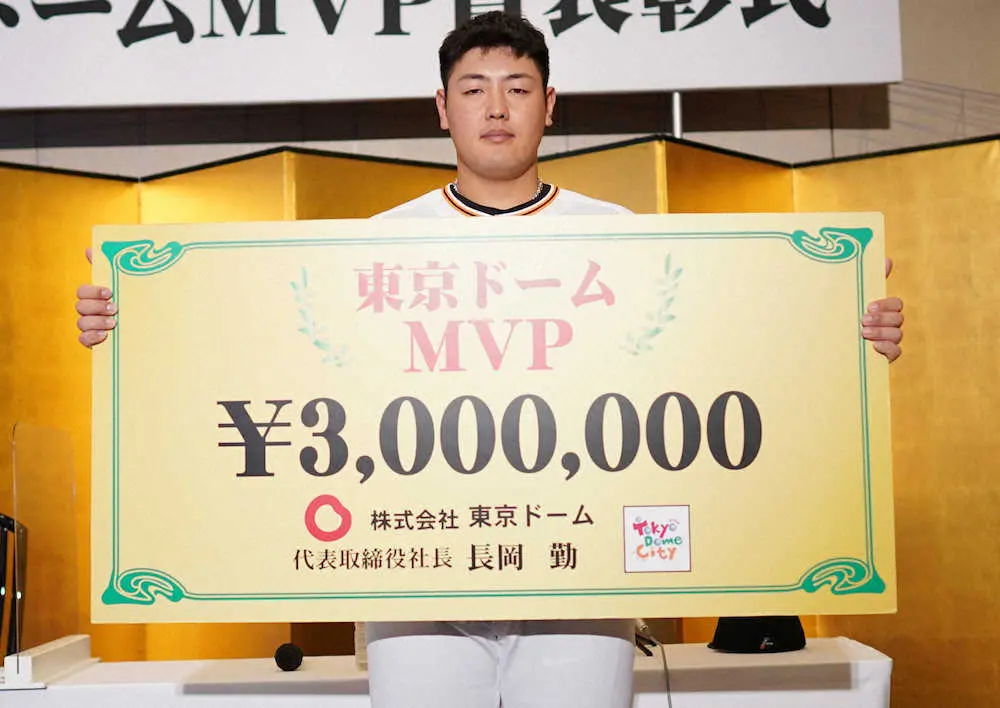東京ドームMVPを獲得し、賞金300万円と書かれたボードを手にする岡本和（撮影・木村　揚輔）