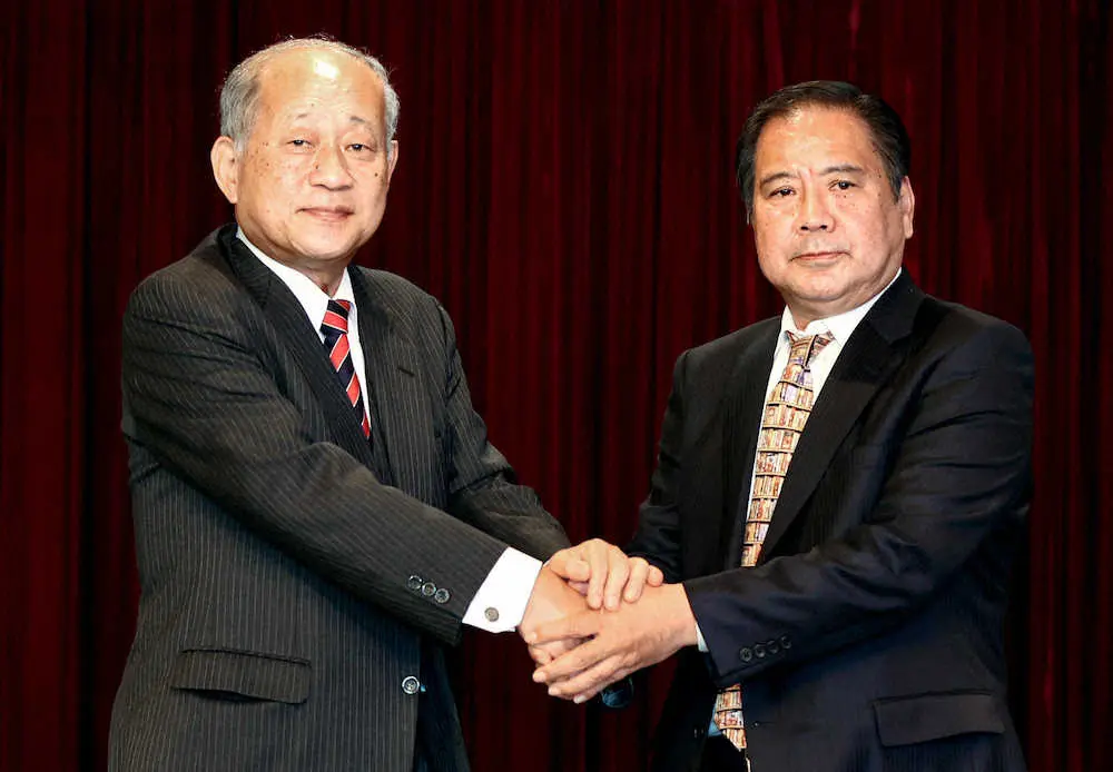 握手をかわす日本高野連の新しい会長に決まった宝馨さん（右）と退任する八田英二会長