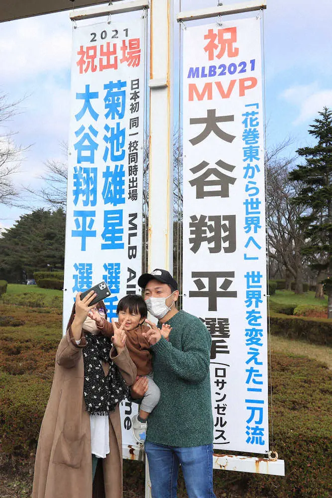 花巻東高校前に飾られた大谷のMVP受賞を記念した垂れ幕を背に記念撮影する人（撮影・河野　光希）