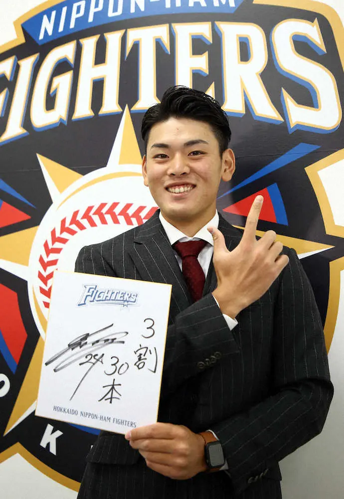 日本ハムの契約更改で来季の目標を書いた色紙を手に指ででJポーズを決める野村（撮影・高橋茂夫）
