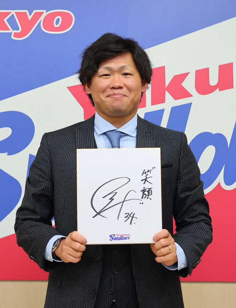 契約更改を終え、「笑顔」と記した色紙を手に写真撮影に臨むヤクルト・田口麗斗