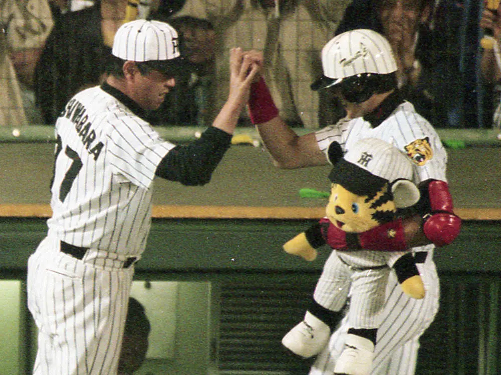 1999年6月12日、阪神―巨人戦　8回、9号ソロ本塁打を放った新庄剛志とハイタッチを交わす柏原純一