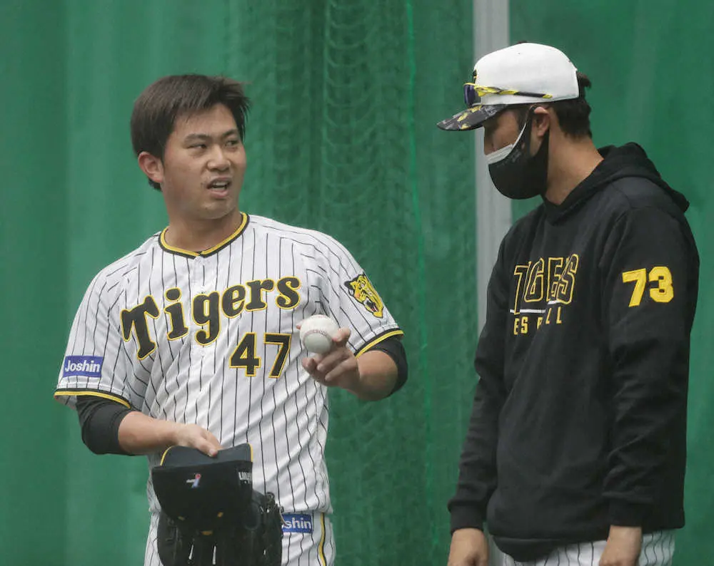 ブルペンで投球後、金村投手コーチ（右）と話す阪神・桐敷（撮影・坂田　高浩）