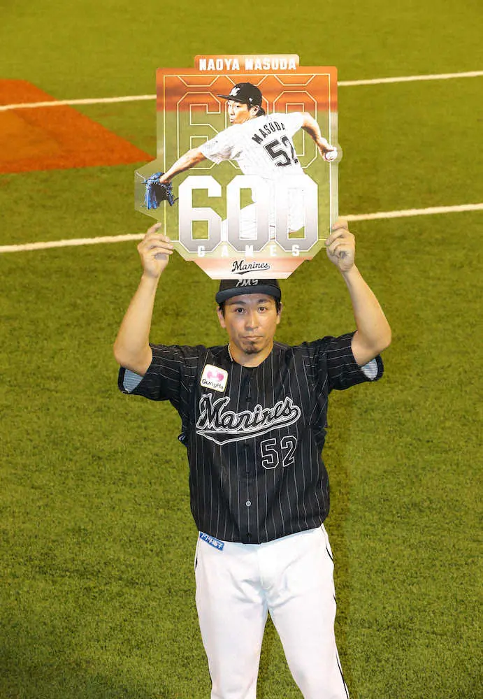 ＜ソ・ロ＞600試合登板を達成した益田は記念ボードを掲げる（撮影・岡田　丈靖）