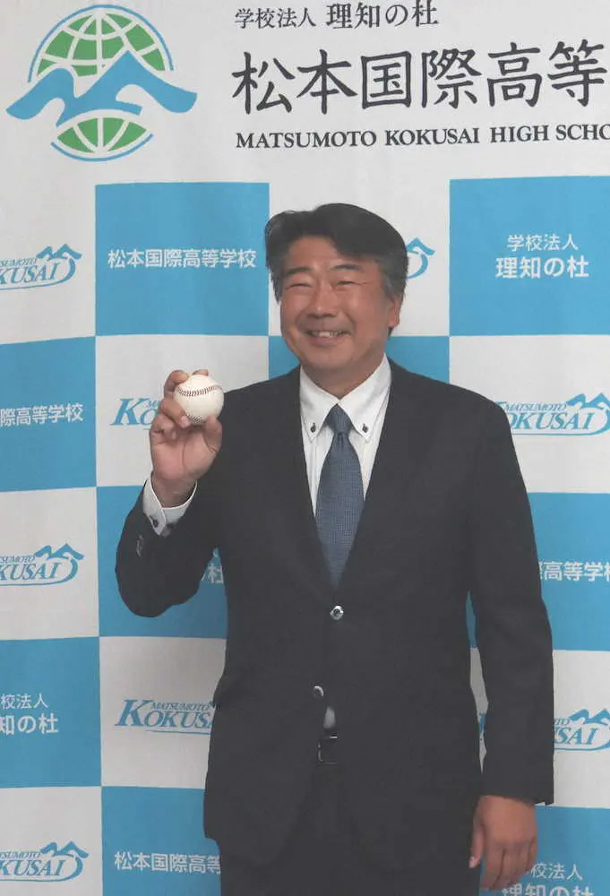 坂田新監督はボールを手に笑顔