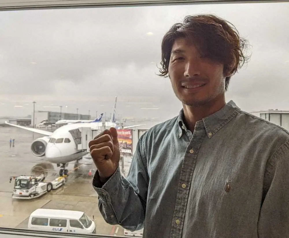 新千歳空港への移動便を背にガッツポーズを見せるDeNA・大田