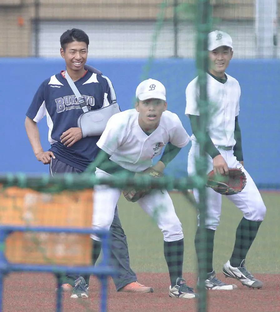 二塁手のノックを見つめる佛教大の主将・田中颯翔（左）