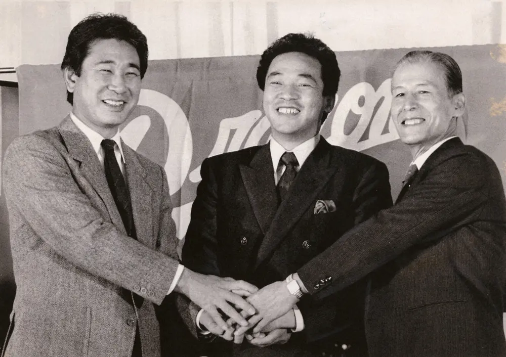 1986年12月26日、中日にトレードとなった落合（中央）は、星野仙一監督（左）、中山了球団社長（右）とガッチリ握手