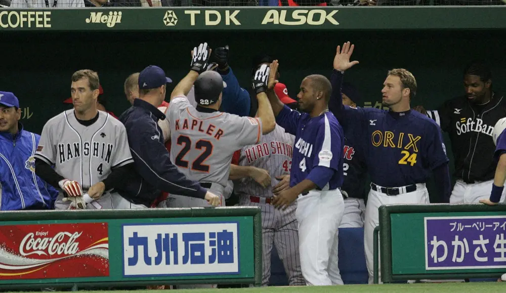 【画像・写真】2005年3月15日、タイムリーで生還した巨人のゲーブ・キャプラー外野手（中央・22番）を出迎える外国人選抜チームベンチ