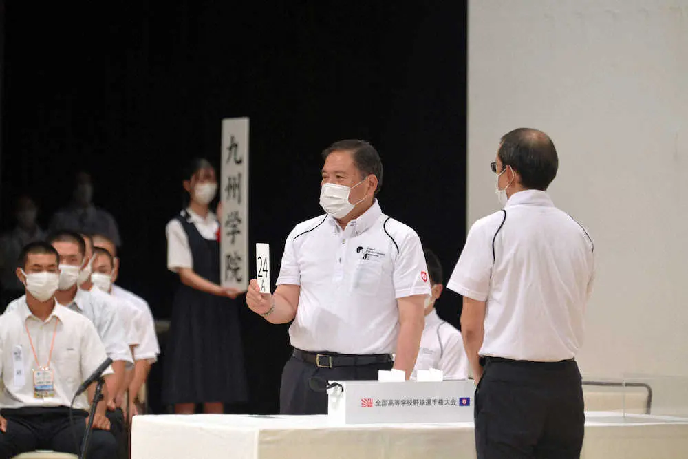 組み合わせ抽選会を欠席した九州学院のくじを代理で引く日本高野連の宝会長（代表撮影）
