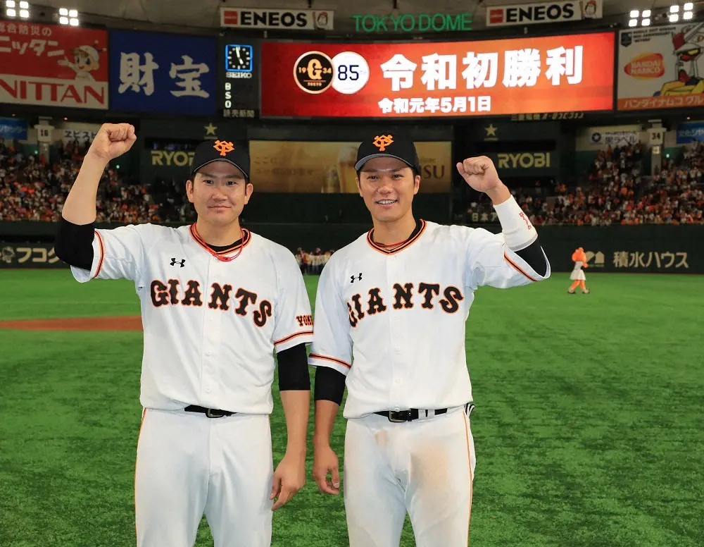 2019年5月1日、「令和初勝利」の前でポーズをとる勝ち投手の先発・菅野（左）と令和１号の坂本
