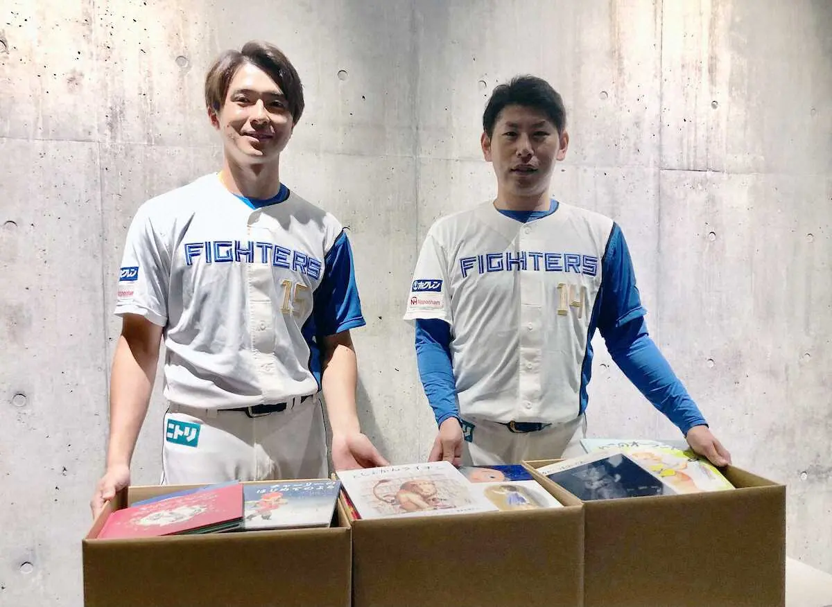 読書促進全道キャンペーン「グラブを本に持ちかえて」で集まった本を手にする日本ハム・加藤貴（右）と上沢（球団提供）
